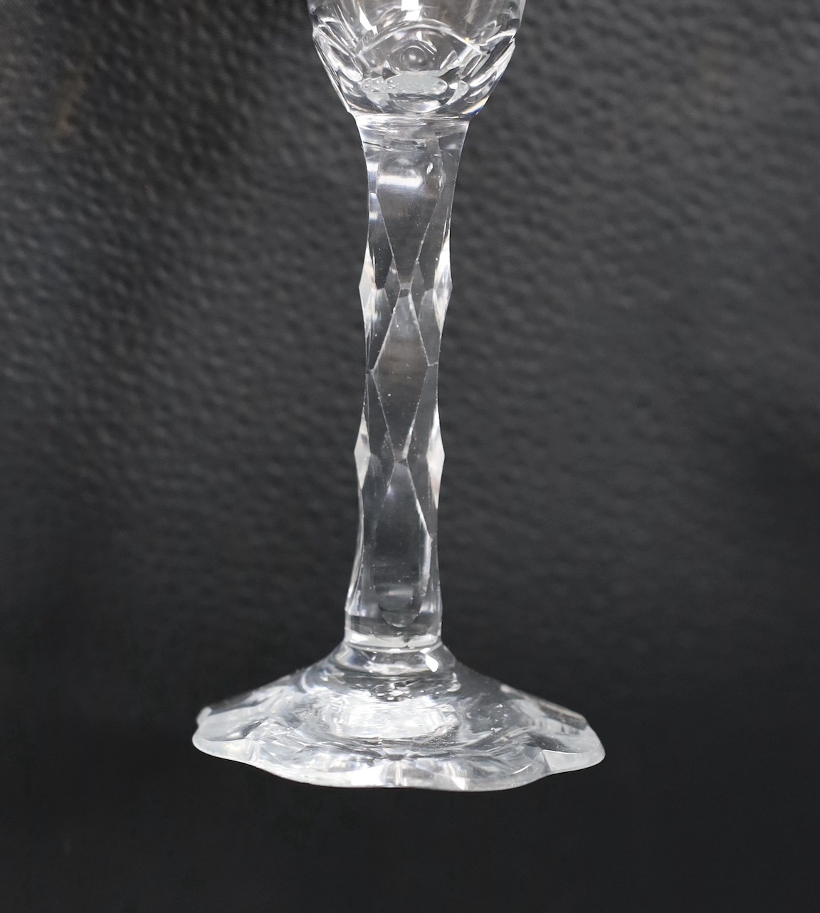 An 18th century facet stemmed glass with a petal foot, 16.5 cms high